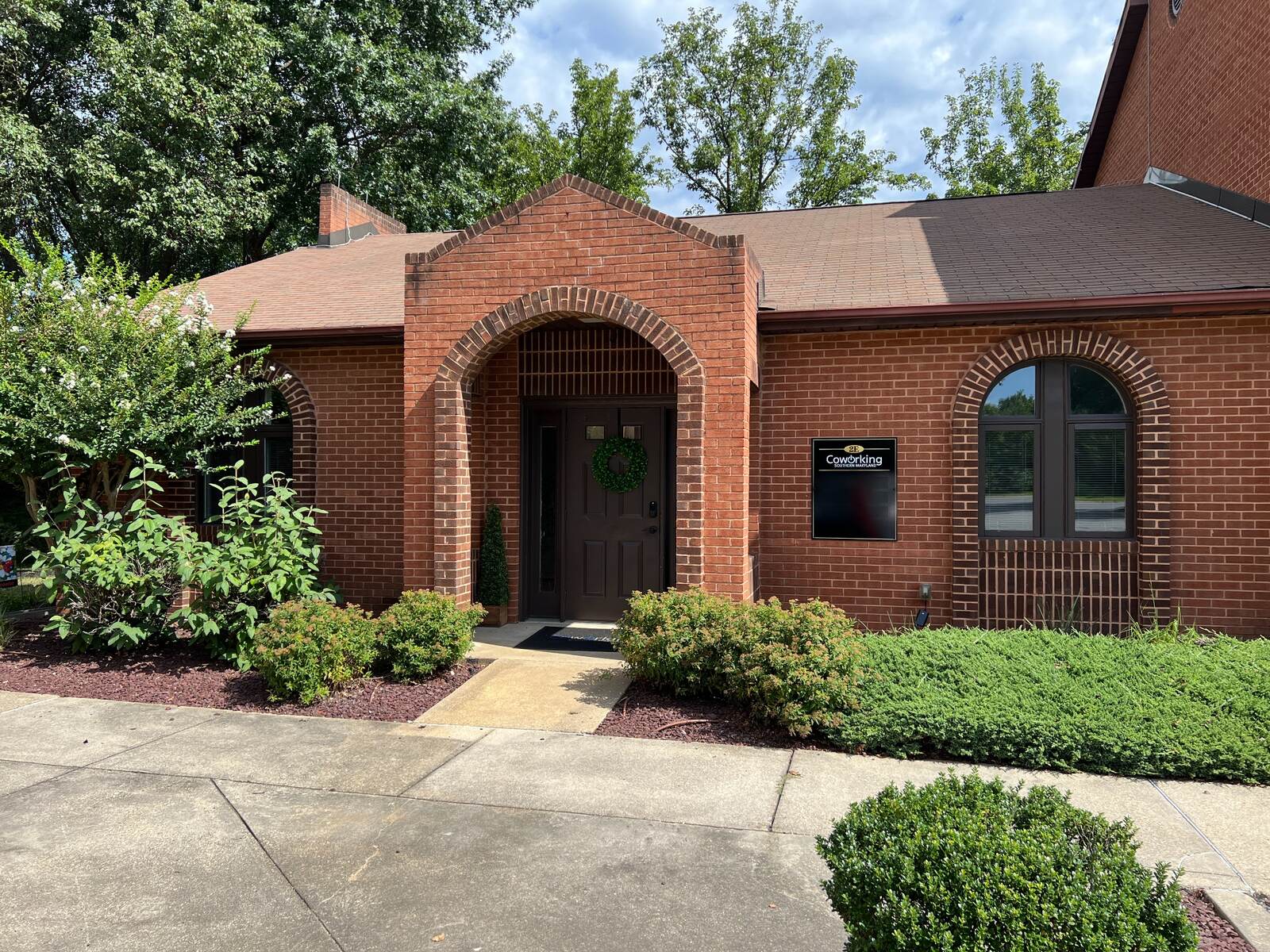 Front entrance to Coworking Southern Maryland's brick building in Waldorf